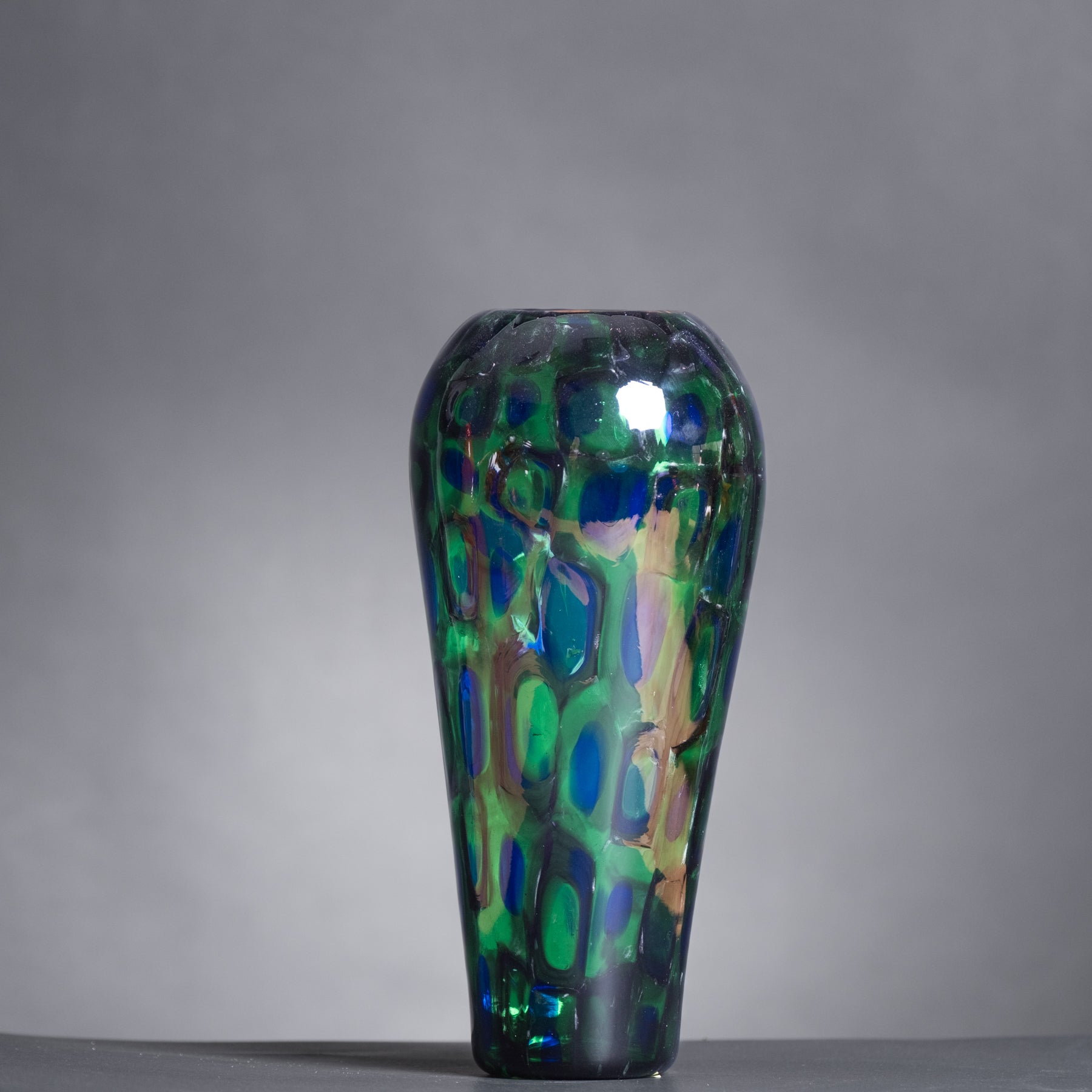 Decorative glass vase with a colorful pattern on a gray background