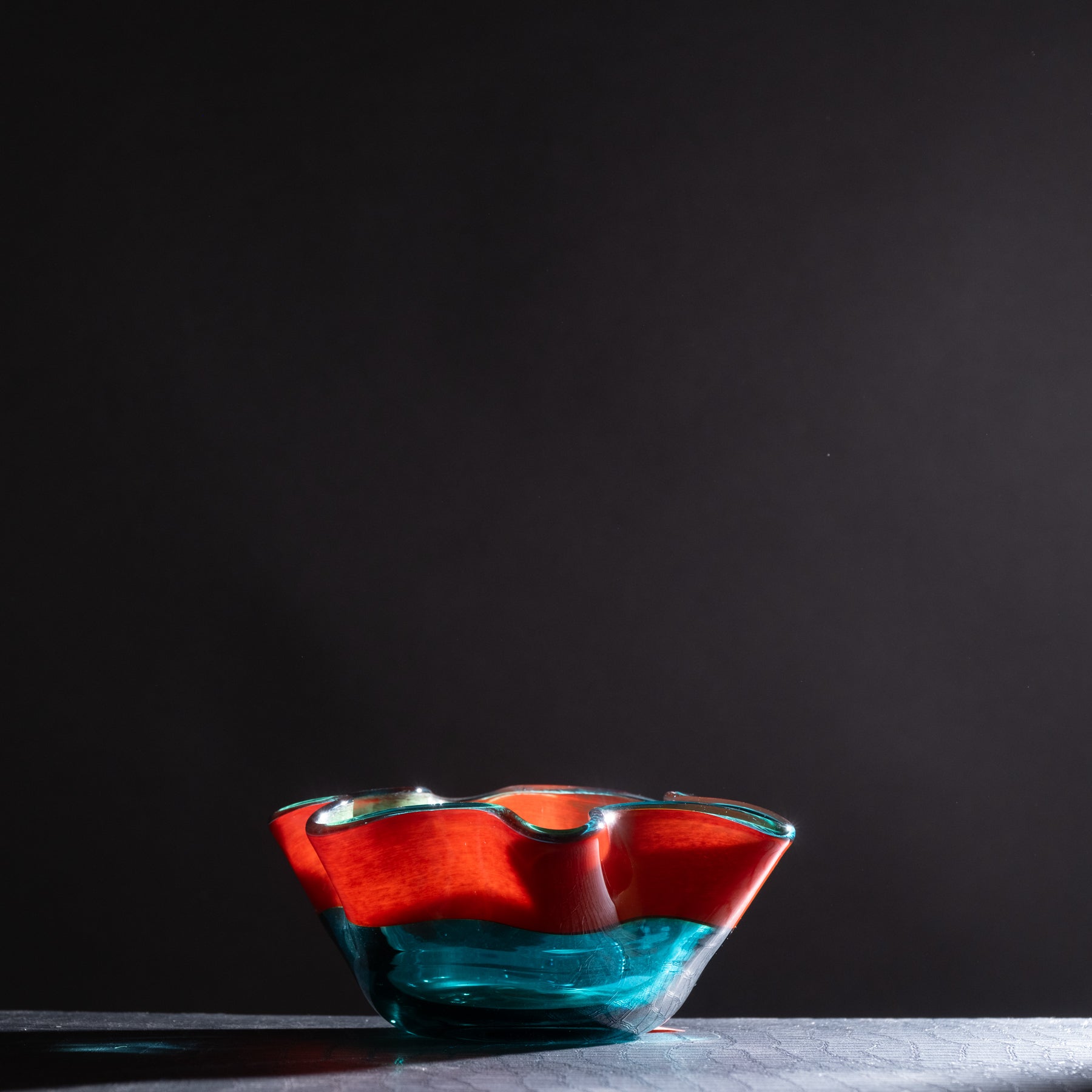 Glass bowl with red and blue gradient on a dark background