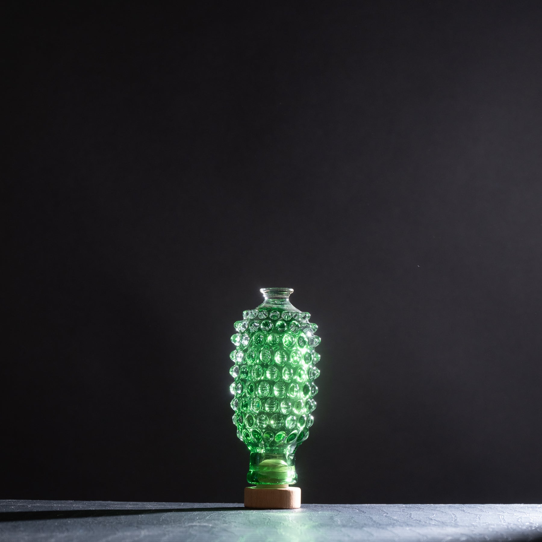 Green textured vase on a dark background