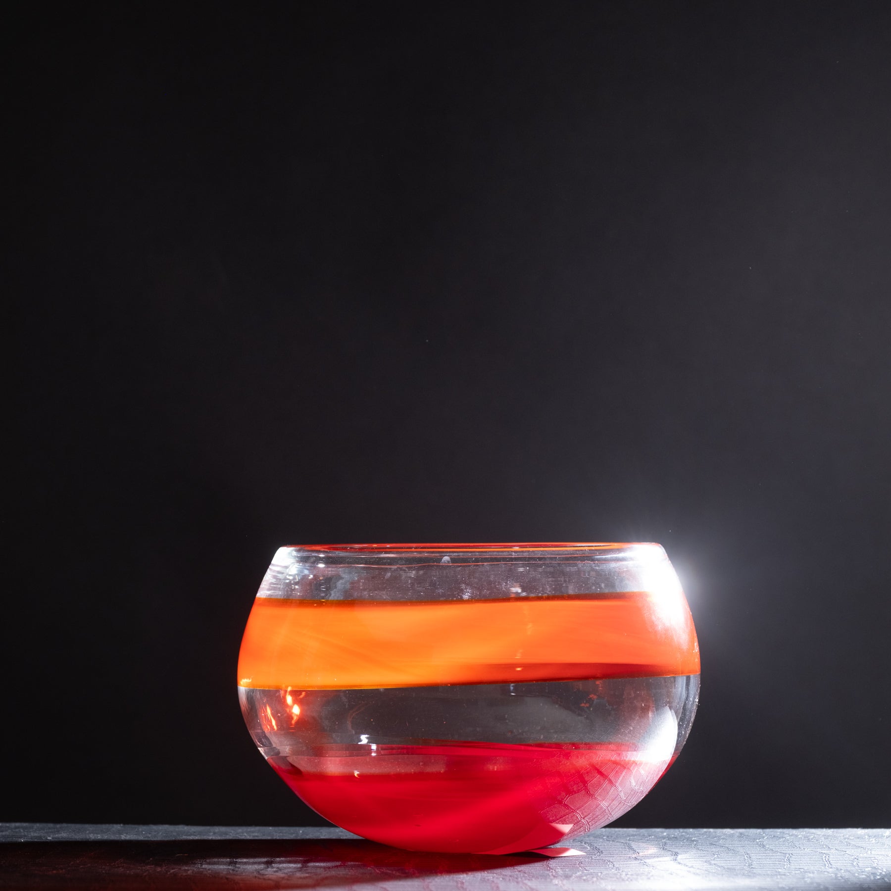 Glass bowl with red and orange gradient on a black background