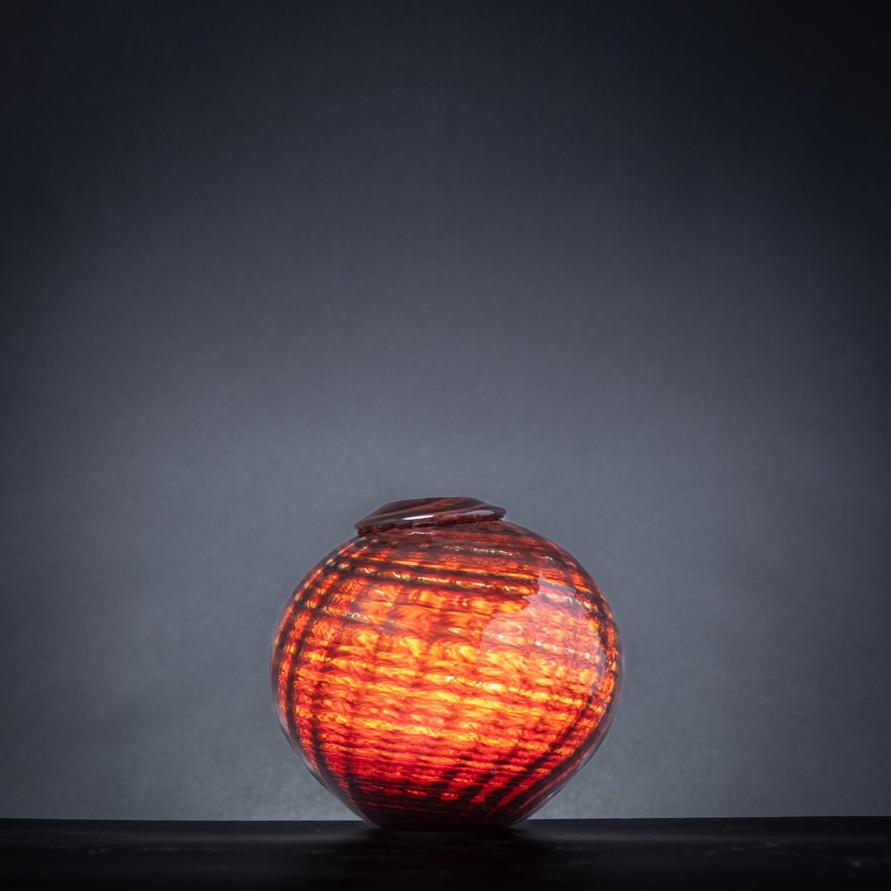 Decorative glass vase with a textured surface on a dark background