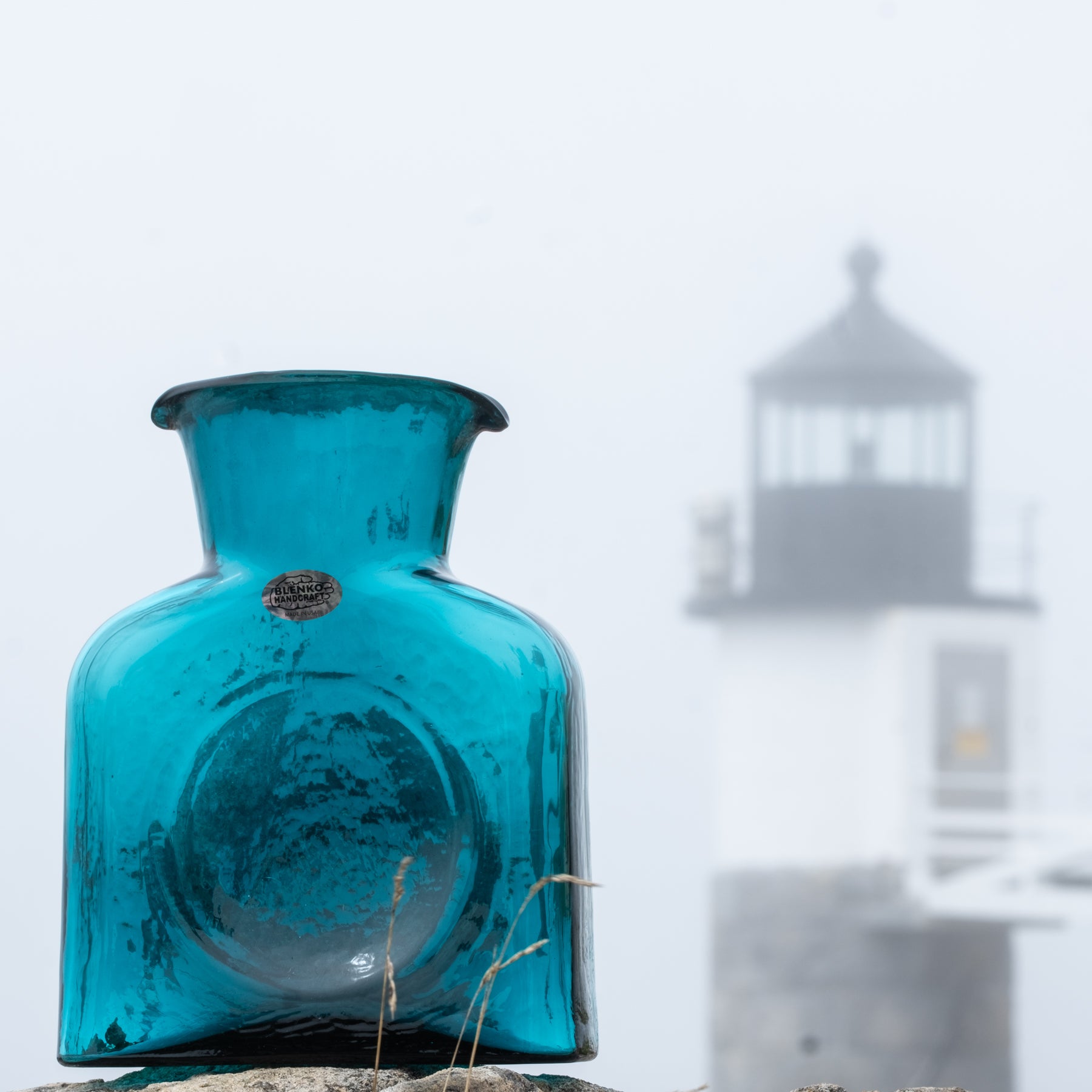 Cerulean water bothers in front of a lighthouse