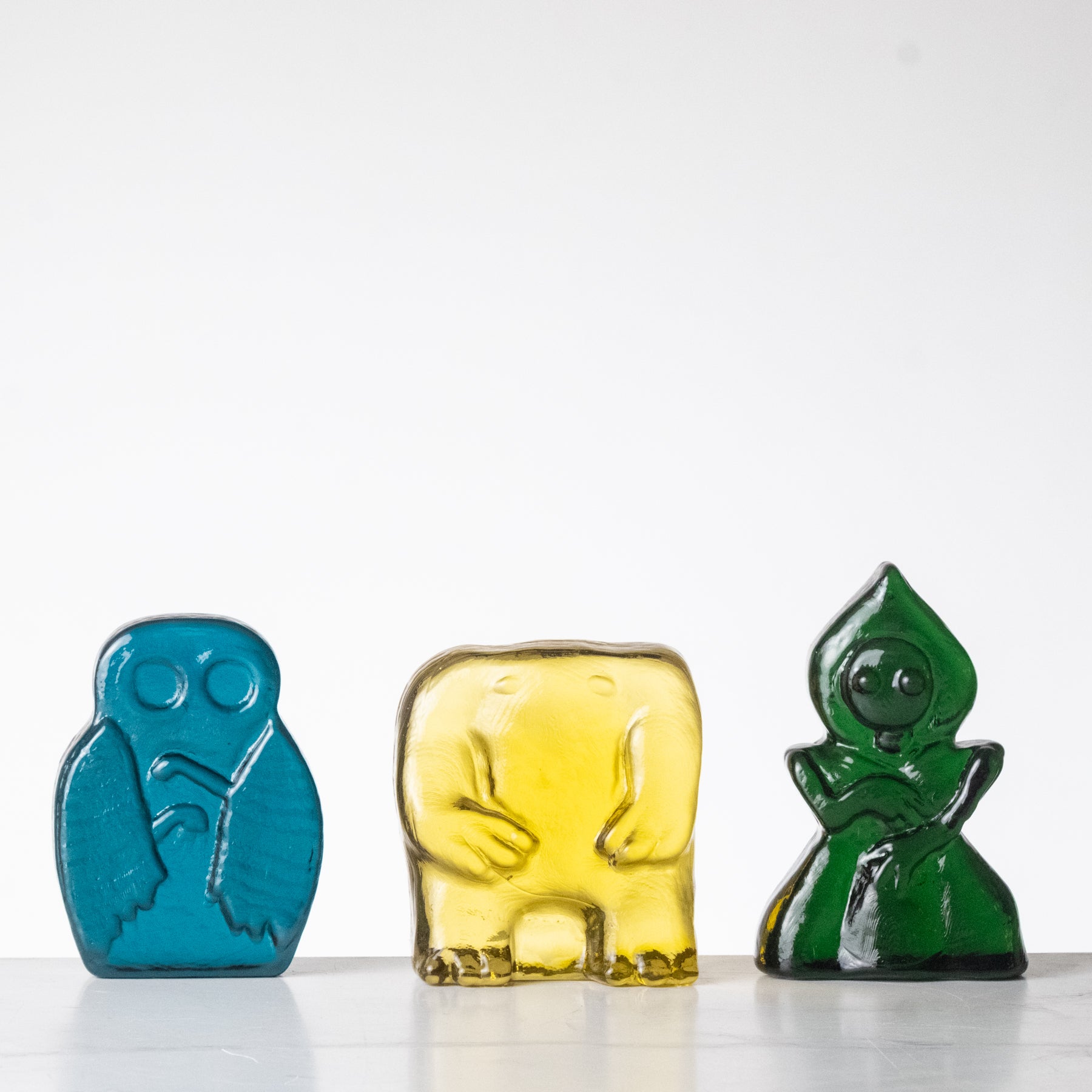 Three colorful glass figures on a white background