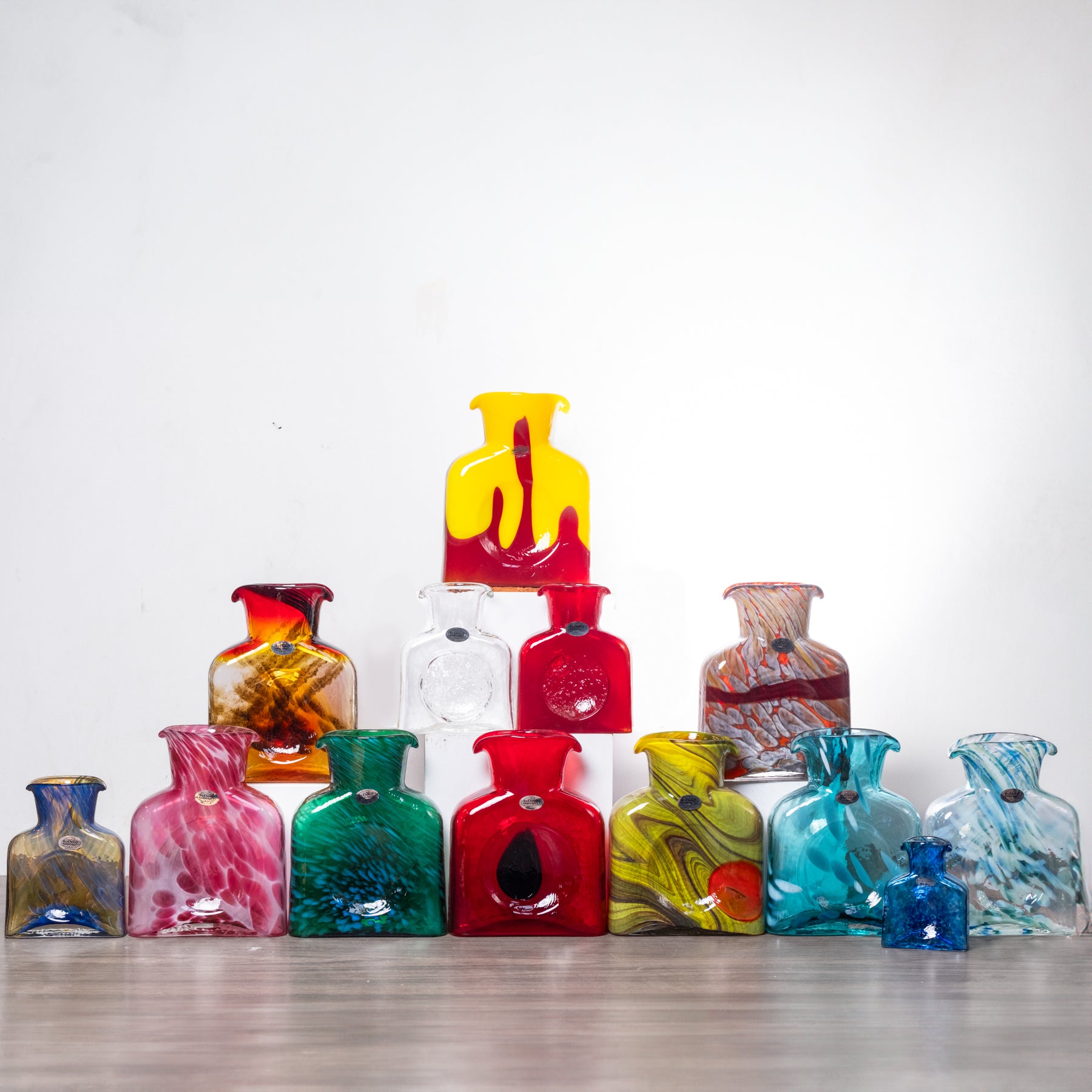 Collection of colorful glass vases on a white background