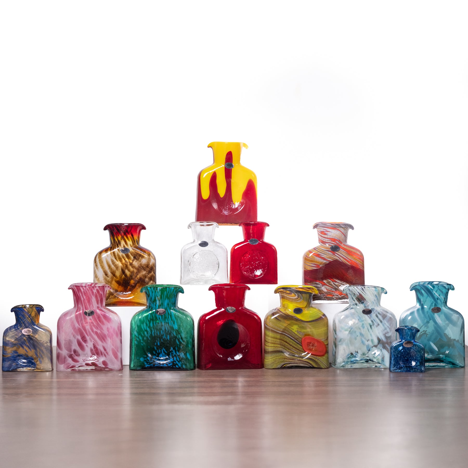 Collection of colorful glass vases on a white background