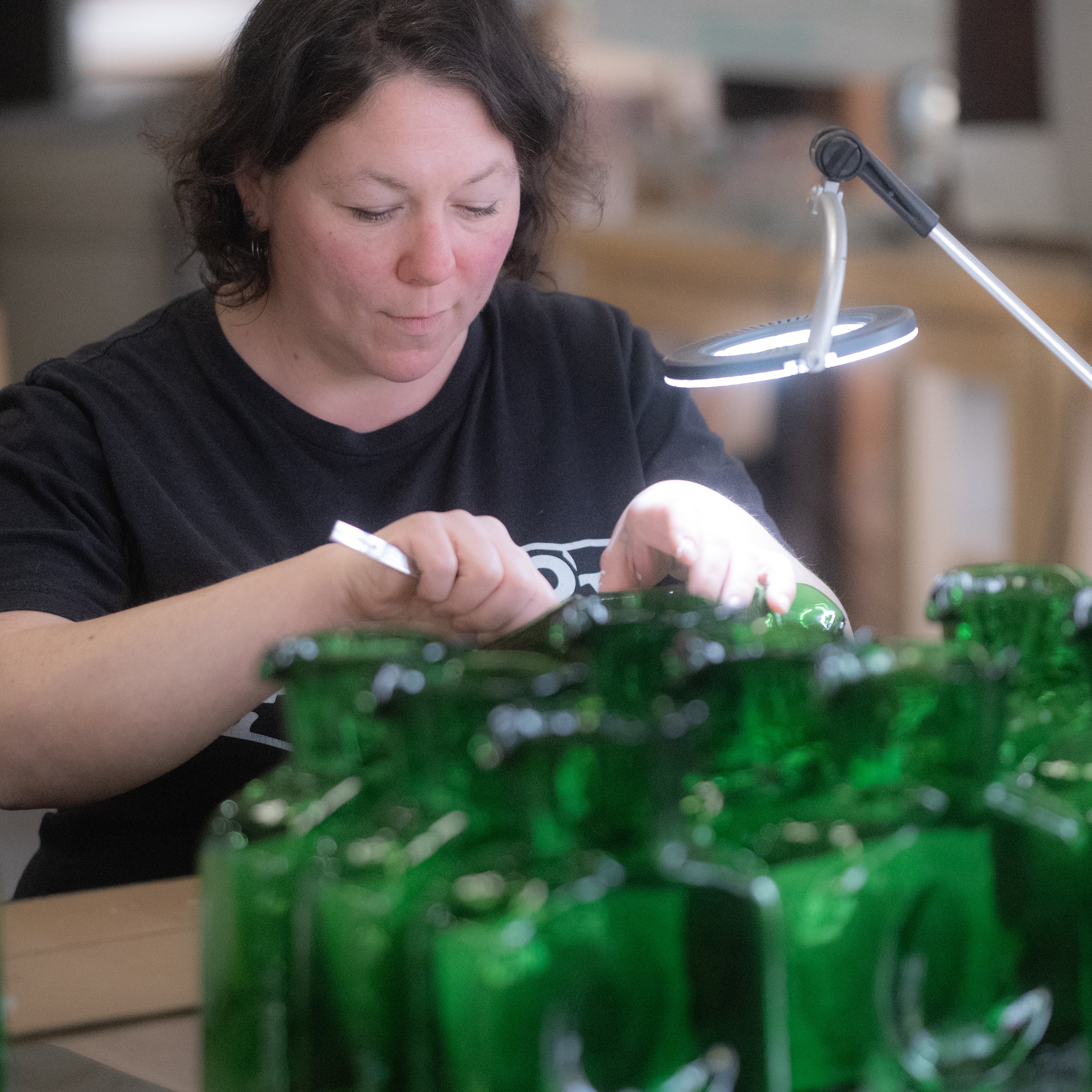 Jenni Gonze working on an etch water bottle.