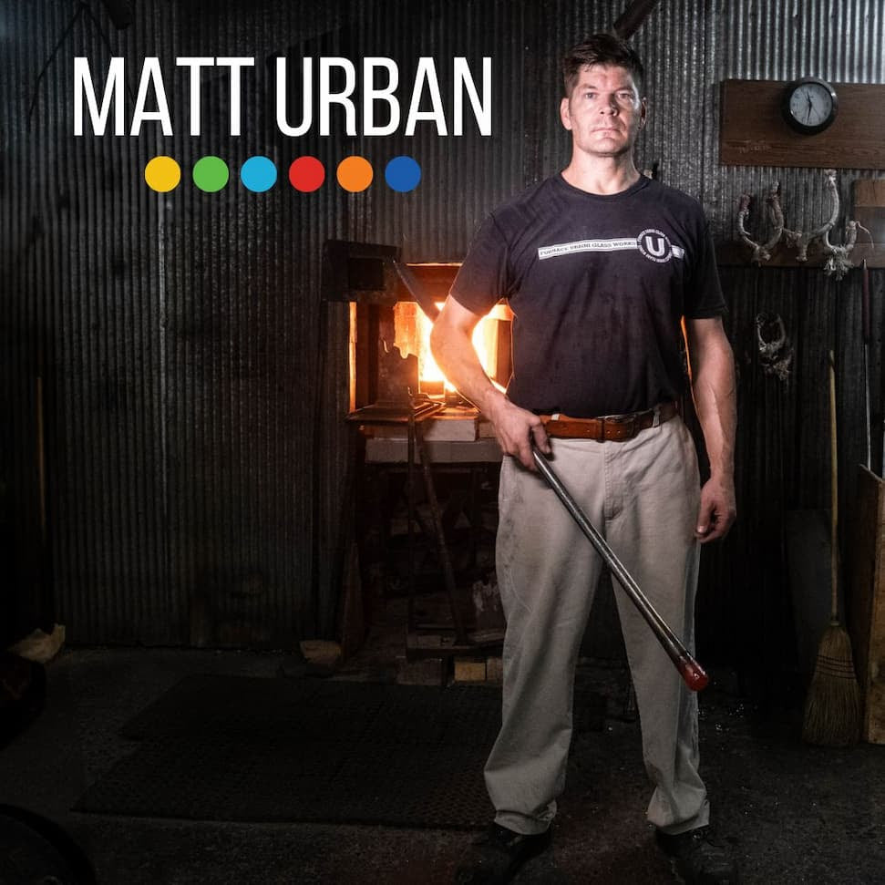 Man holding a baseball bat in a workshop with 'Matt Urban' branding.