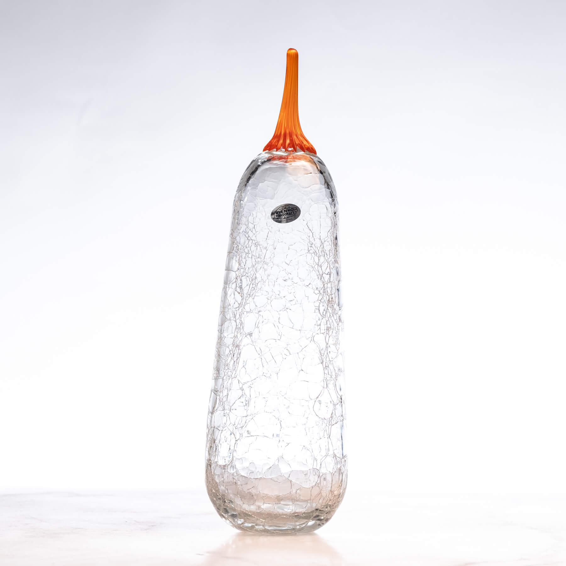 Crackle crystal glass pumpkin with an orange stem on a white background