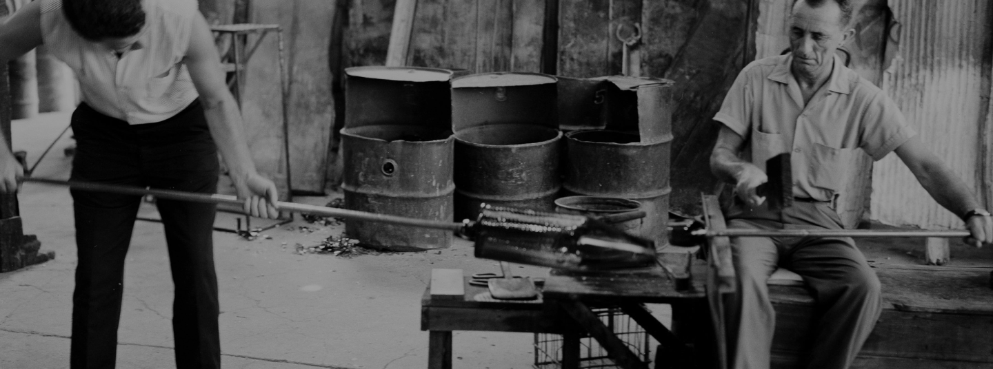 A old photos in black and white of two Blenko Glass workers in the factory.