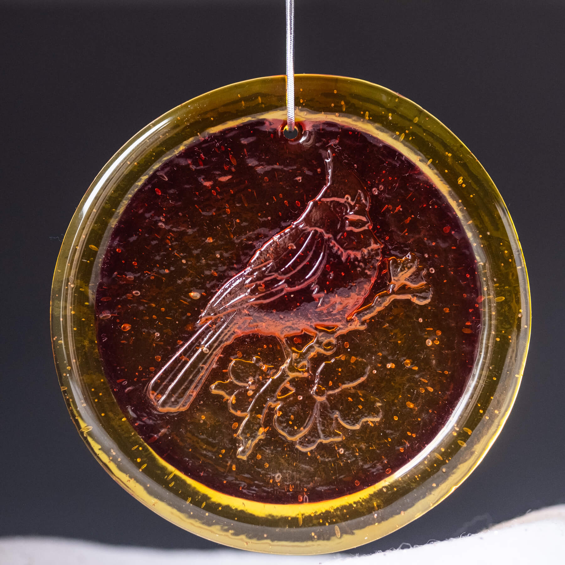 tangerine sun-catcher with a cardinal on it